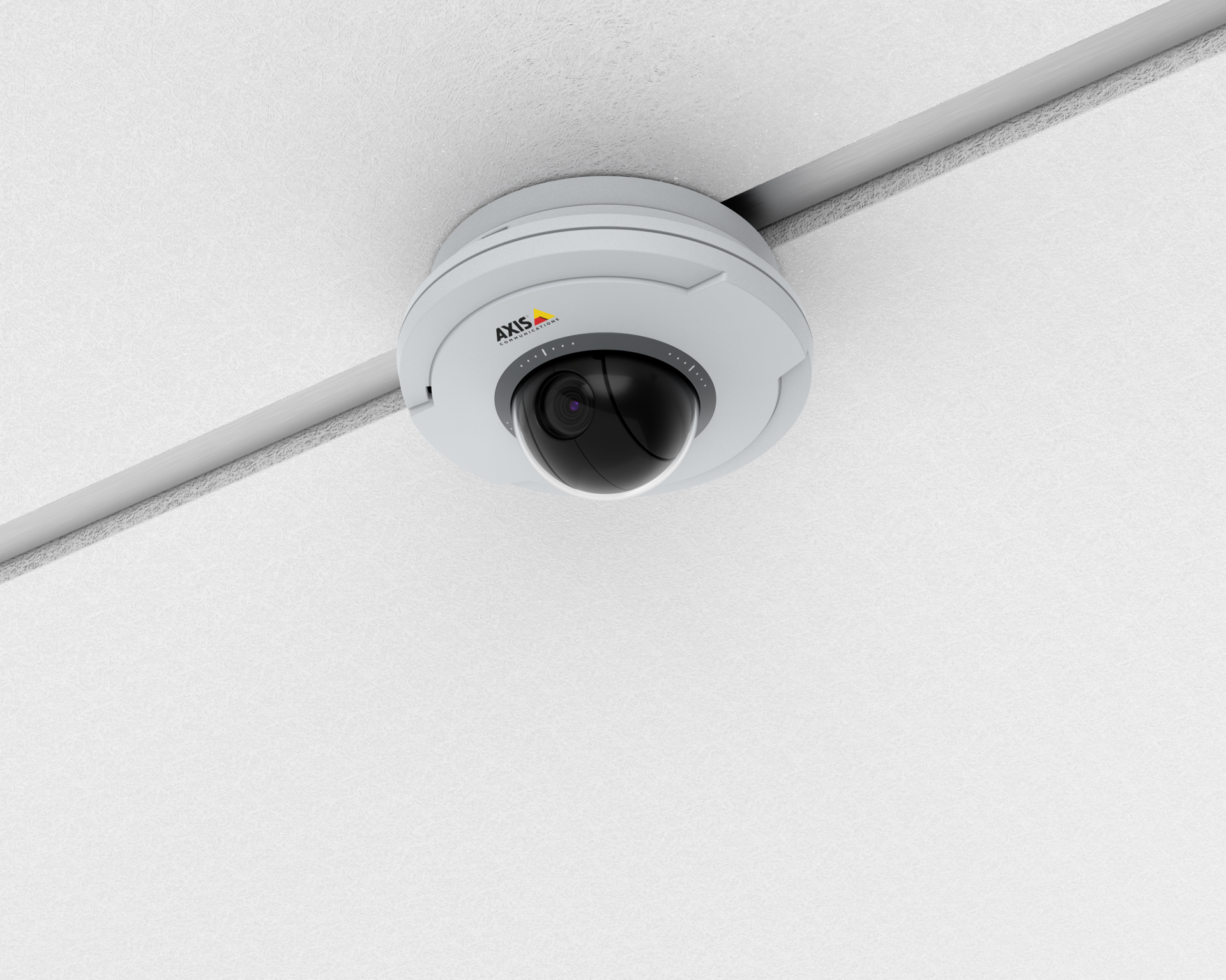 AXIS M5074 mini dome network camera mounted flush to a white ceiling at the intersection of two ceiling grid rails.