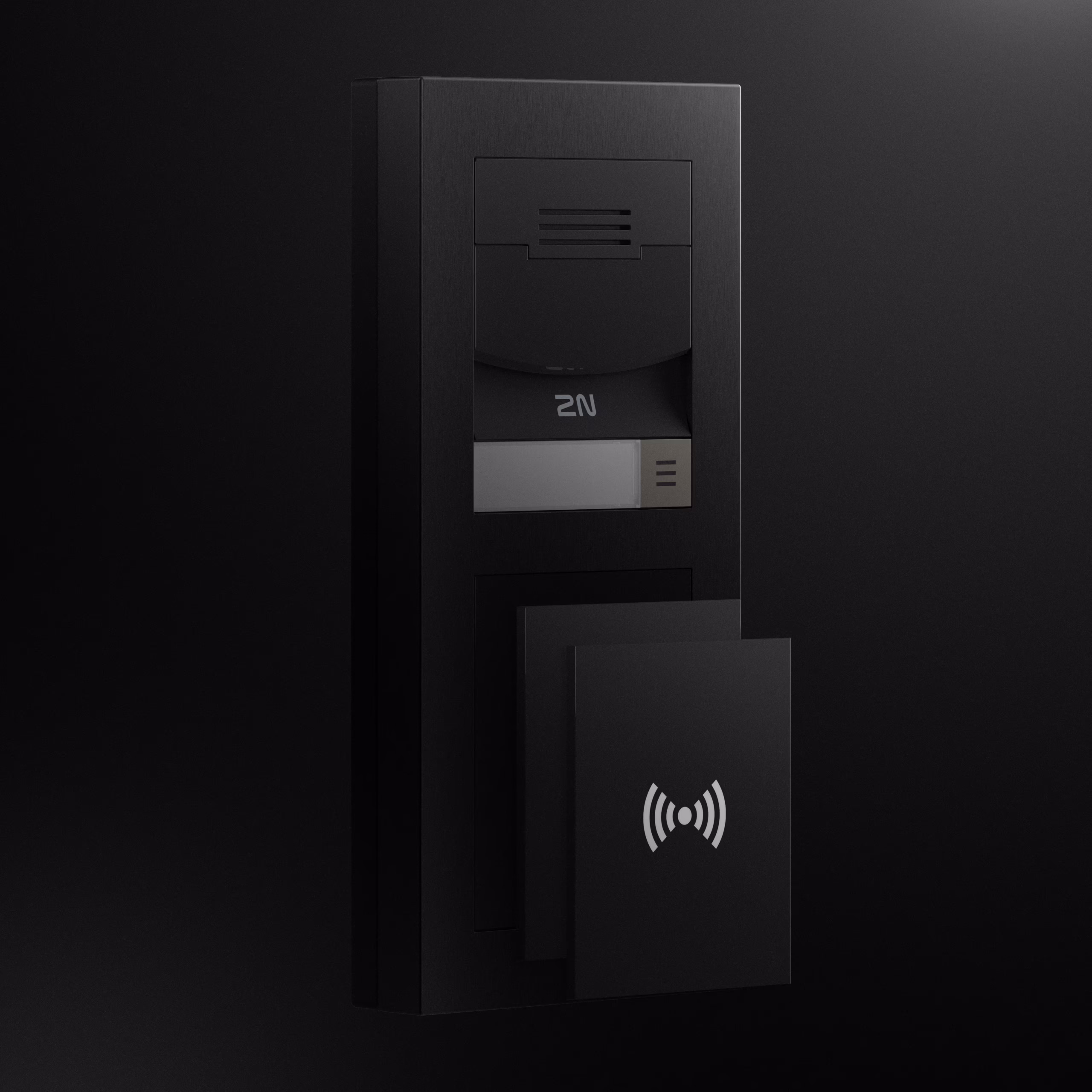 A sleek, matte black 2N IP Verso 2.0 modular intercom mounted on a wall. A hand is holding a black RFID proximity card up to the contactless reader module at the bottom.