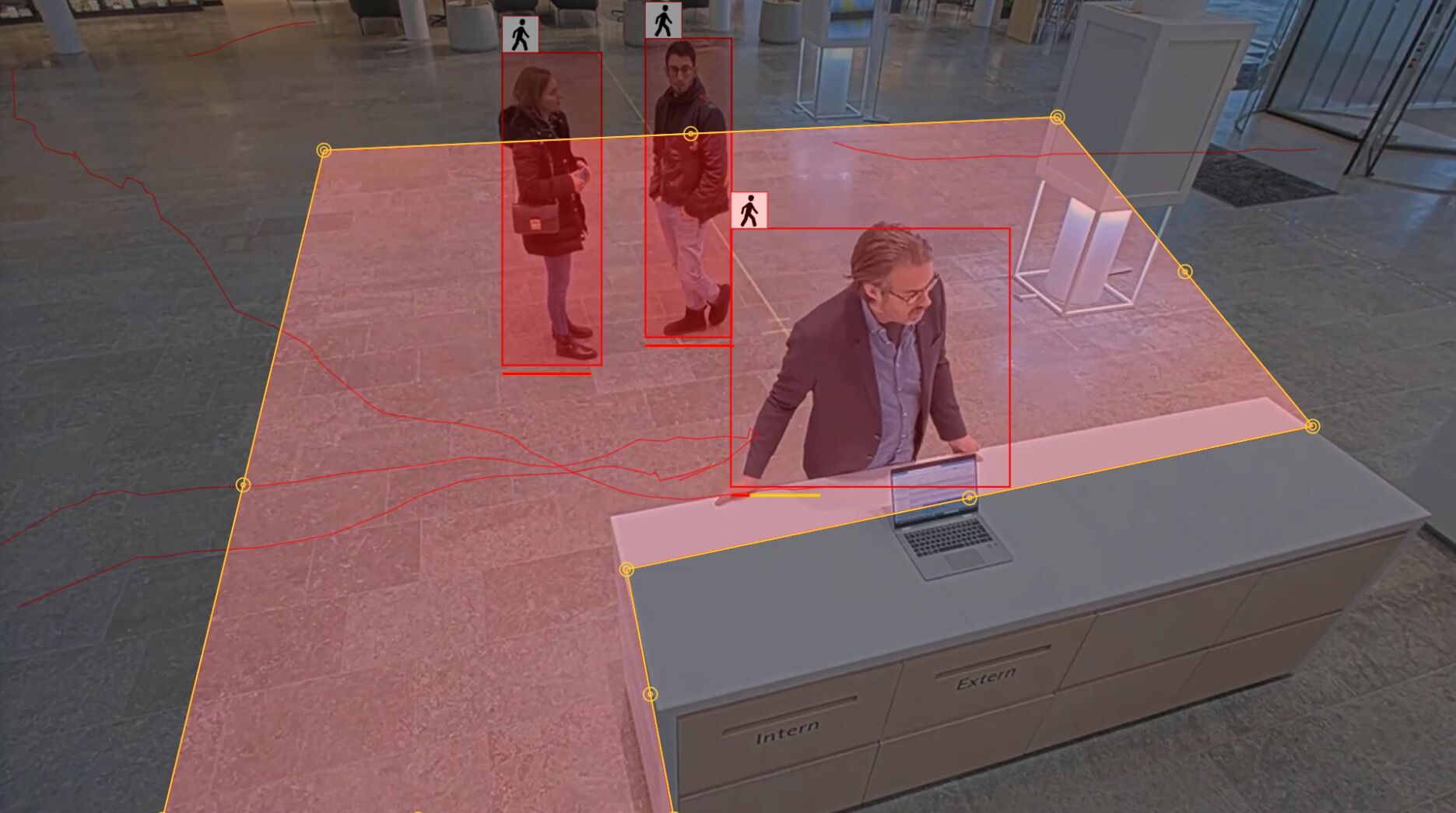 A security camera view of an indoor lobby tracking three people with red bounding boxes and movement lines. A large yellow polygon defines a specific floor zone for monitoring dwell time.