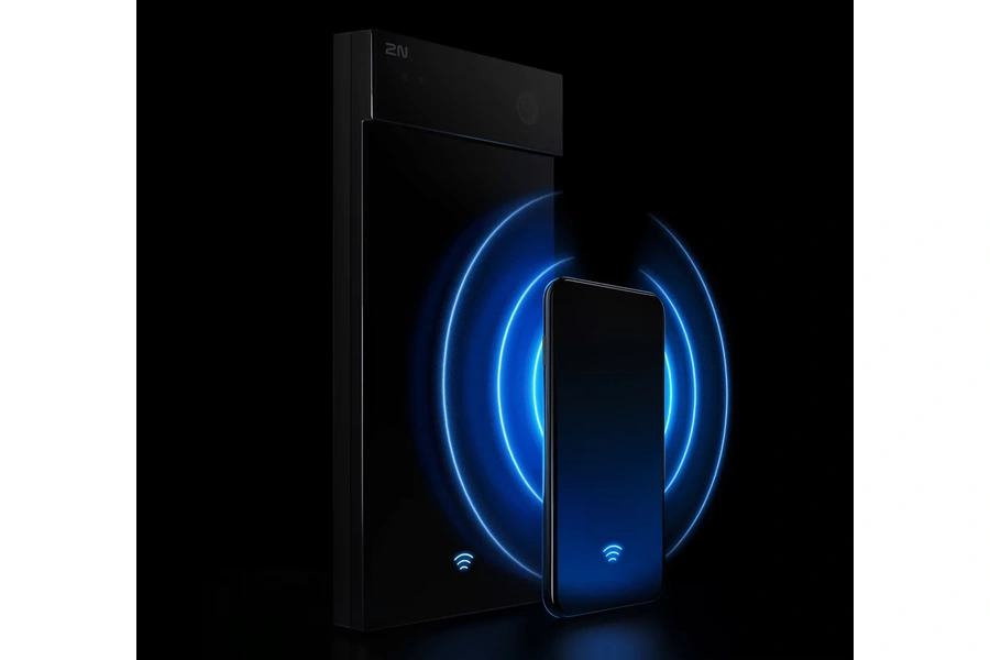 A sleek, black 2N IP Style door intercom unit interacting wirelessly with a smartphone via glowing blue signal waves against a dark background.