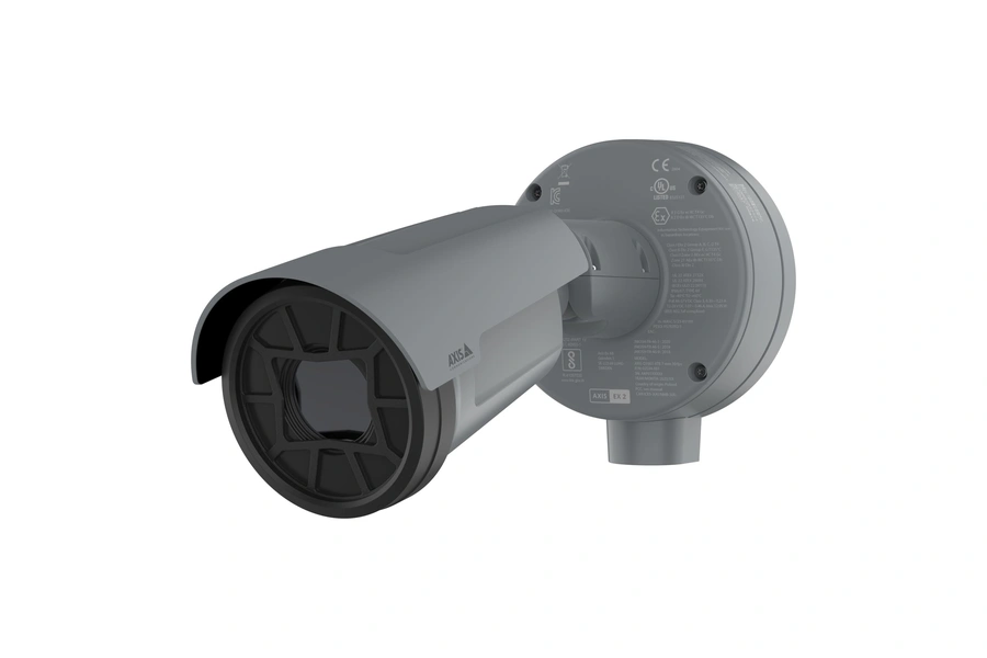 A left-hand side-angle view of the gray AXIS Q1961-XTE explosion-protected thermal camera, featuring a black protective grill over the lens and a circular mounting base covered in industrial safety certification markings.